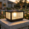 Square solar pillar light glowing on a stone pillar at dusk
