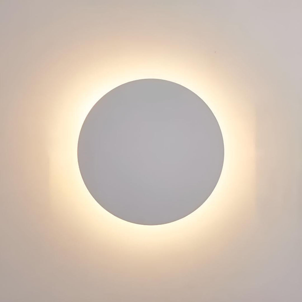 Round wall sconce lit in a modern staircase