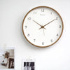 Minimalist wooden clock hanging in a study