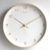 Cream solid wood silent wall clock on a pale wall